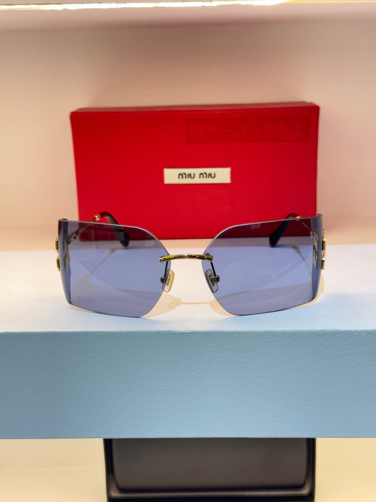 Miu Miu sans cerclage, verres géométriques bleutés et détails dorés — photo réelle 1 de la paire chez NVL