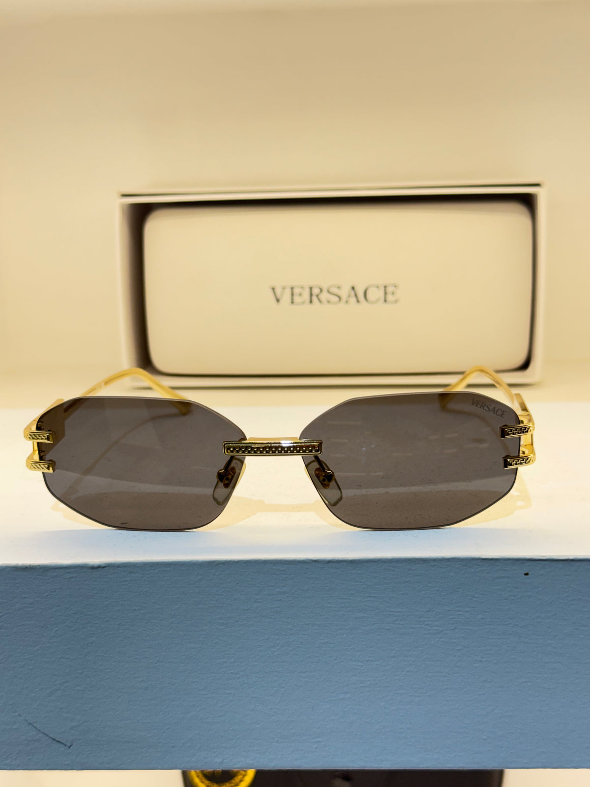 Versace sans cerclage, verres géométriques gris et détails dorés — photo réelle 1 de la paire chez NVL